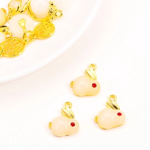 Macro detail of white jade-like rabbit charm with gold accents and lucky福 symbol pendant