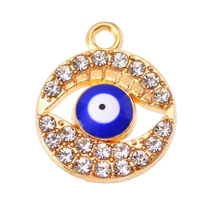 Macro shot of gold alloy evil eye pendant with blue enamel and sparkling rhinestones