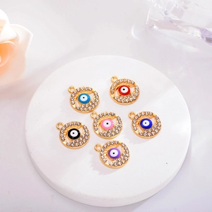 Set of six colorful Evil Eye pendants with sparkling rhinestones and gold plating on stone tray