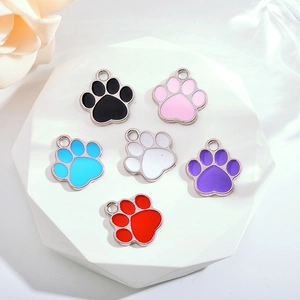 Set mit sechs bunten Katzenpfoten-Anhängern für DIY-Schmuck auf weißem Steinständer