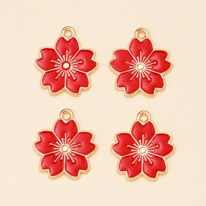 Detail van vier rode kersenbloesem hangers van legering voor DIY sieraden maken van goud