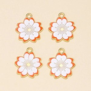 Detail van oranje en witte emaille kersenbloesem hangers met gouden metalen randen