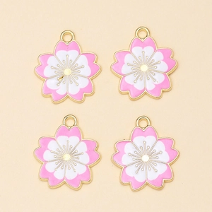 Detailweergave van vier kersenbloesem hangers van legering met roze en wit emaille