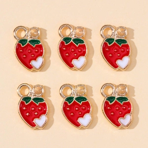Detail of red enamel strawberry charms for DIY jewelry making with white heart accents