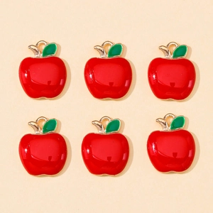Flat lay of red enamel apple charms with green leaves and gold-plated alloy loops