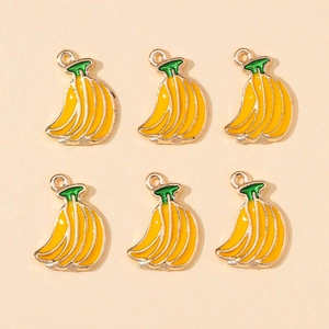 Detail of six yellow banana charms with gold edges and green stems for DIY jewelry making