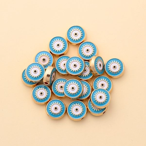 Macro detail of 10mm gold evil eye alloy beads with blue enamel for DIY jewelry making