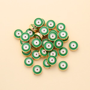 Macro detail of 10mm gold-plated green evil eye beads for DIY jewelry making