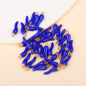 Macro shot of dark blue glazed chili pendants with gold metal rings for DIY jewelry