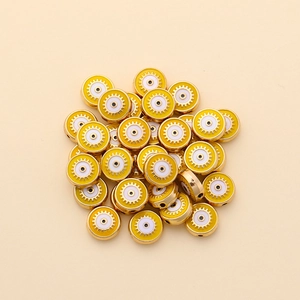Macro shot of 10mm yellow enamel evil eye beads with golden edges for DIY jewelry making