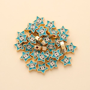 Macro detail of star-shaped evil eye beads with blue enamel and golden alloy edges