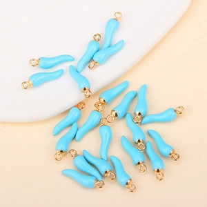 Macro shot of sky blue enamel chili pendants with gold rings for DIY jewelry making