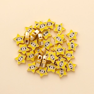 Detail of yellow star-shaped evil eye beads with golden edges for DIY jewelry making