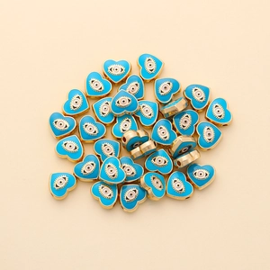Macro view of heart-shaped evil eye beads with light blue enamel for jewelry DIY