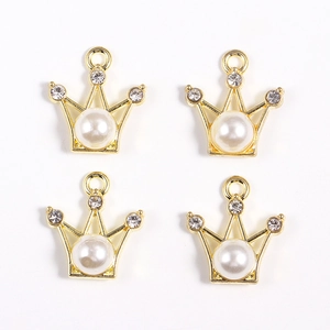 Détail de pendentifs couronne en alliage avec perles et strass disposés en grille 2x2
