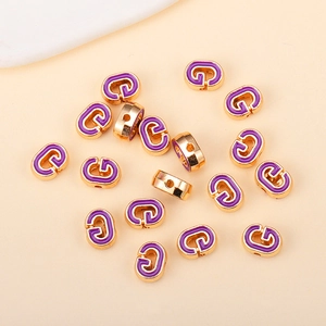 Vue détaillée des perles dorées lettre G avec émail violet pour bijoux faits main