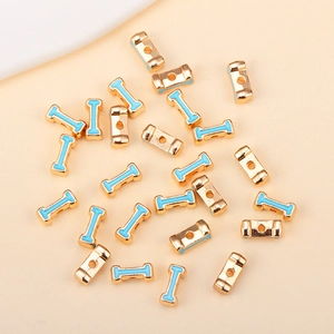 Vue macro de perles alphabet plaquées or avec émail bleu clair pour bijoux DIY