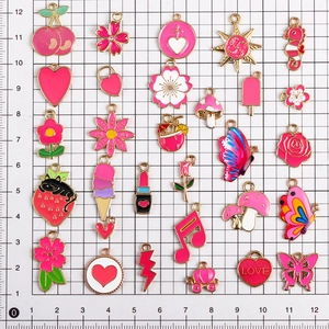 Makroaufnahme verschiedener rosa Emaille-Anhänger auf weißem Maßstabshintergrund