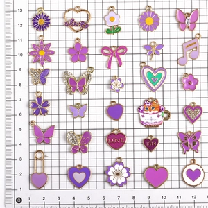 Flachbild von lila Emaille-DIY-Anhängern wie Schmetterlinge und Herzen auf Gitterhintergrund
