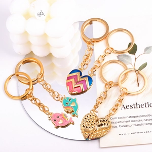 Creative metal heart keychains with whale and geometric charms on reflective base