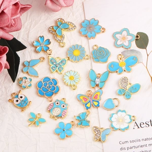 Makro-Detail von himmelblauen Emaille-Anhängern mit weißen Strasssteinen und Blumen