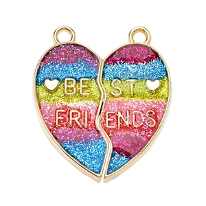 Close-up of heart-shaped magnetic Best Friends charms with colorful glitter and gold plating