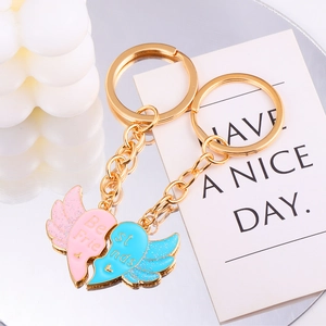 Detail of Best Friends angel wing heart keychains with pink and blue enamel finish