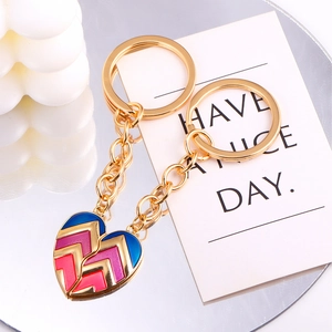Detail of interlocking heart puzzle keychains with vibrant colorful enamel on gold finish