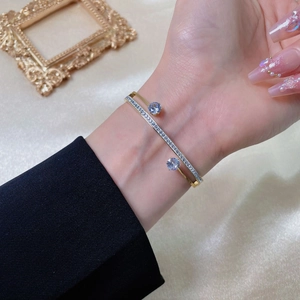 Double-layered gold titanium steel bracelet featuring zircon diamonds and light blue gemstones