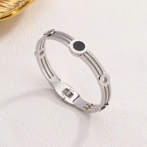 Silver triple-strand cable bangle featuring Roman numeral dial with black center inlay