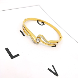 Eleganter goldener Armreif mit großem Zirkon und Wellenmuster mit Mikro-Pave-Steinen