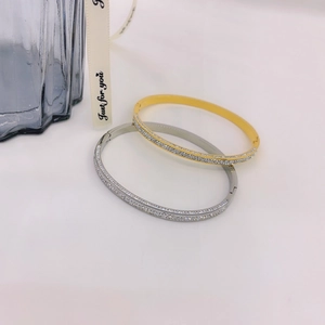 Close-up of gold and silver titanium steel bangles with sparkling zircon stone rows