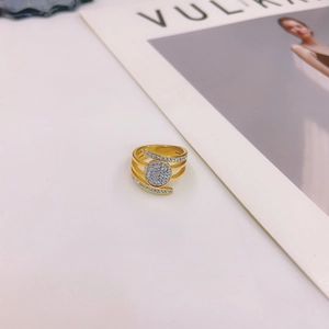 Modern gold layered open ring with sparkling micro-pave zircon crystals on a white desk