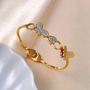 Brazalete de acero de titanio dorado con mariposas de circonita y dije de corazón