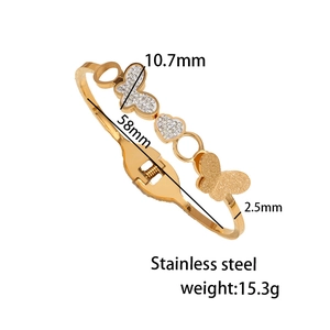Brazalete de acero de titanio dorado con dijes de mariposa y corazón y diamantes de imitación