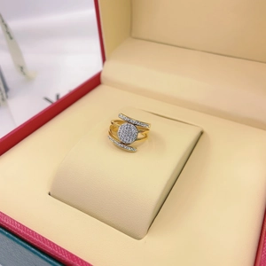 Detailed view of a multi-layer gold cross ring with micro-pave crystals in a red gift box
