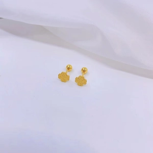 Detailed macro view of 18K gold-plated clover stud earrings with matte frosted finish texture