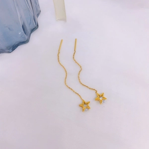 Minimalist gold star threader earrings with sparkling cubic zirconia on light fabric