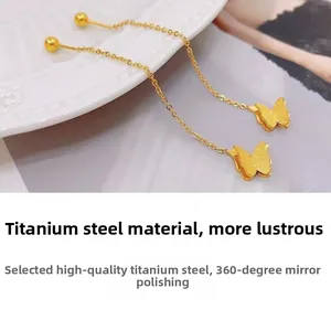 Detailed view of polished titanium steel butterfly tassel earrings on ceramic tray