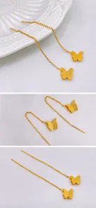Detailed views of gold butterfly threader earrings with a frosted matte metal finish