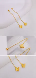 Detailed view of golden butterfly threader earrings with matte texture and fine chain