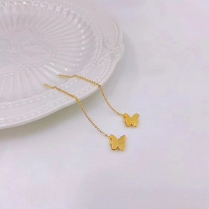 Elegant gold titanium butterfly long ear threaders with frosted finish on ceramic plate