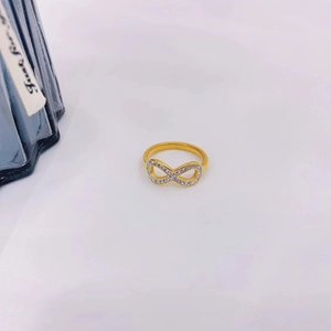 Detailed macro view of an 18K gold plated infinity ring with sparkling white zirconia stones