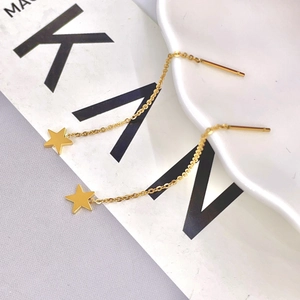 Elegant gold titanium steel star threader earrings with fine chain dangles on a white dish