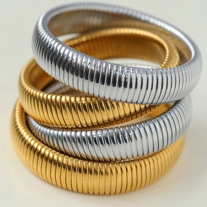 Gestapelde goud- en zilverkleurige minimalistische geribbelde titanium stalen armbanden