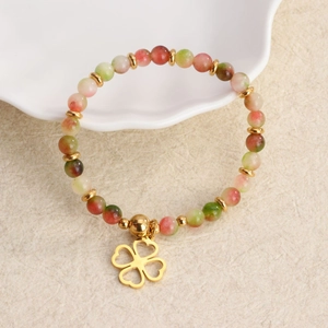 Kleurrijke natuurstenen kralenarmband met gouden klavertje vier op textuur