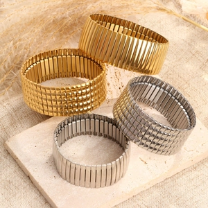 Set de pulseras elásticas de acero inoxidable en oro y plata sobre soporte de piedra