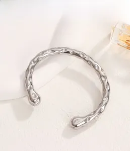 Dettaglio del bracciale rigido a C in acciaio inossidabile argento con finitura martellata