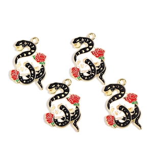 Detailed view of four gothic enamel charms with snake, skull, and rose for DIY jewelry