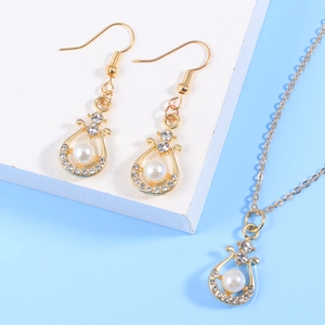 Parure élégante en alliage doré avec perles et strass sur fond bleu clair